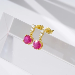 Detailed close-up of 925 silver star earrings with pink gems and gold plating