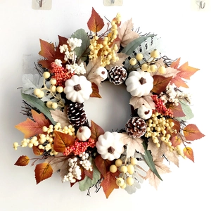 Detailed close-up of autumn garland with white pumpkins, pine cones and fall berries