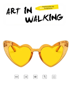 Detailed front view of glitter heart-shaped sunglasses with yellow transparent HD lenses