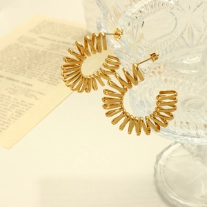 Boucles d'oreilles créoles dorées en forme de C avec design spirale sur fond blanc chic