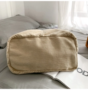 Detail view of beige corduroy tote bag showing rectangular base and ribbed texture