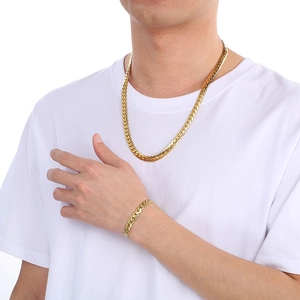 Gold stainless steel Cuban link chain necklace and bracelet set for men on a model