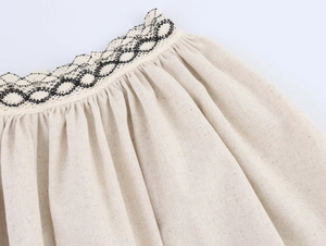 Gros plan détaillé sur lin beige avec bordure en dentelle noire et texture plissée