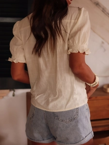 Women's V-neck floral embroidered shirt with ruffled short sleeves and denim shorts back view
