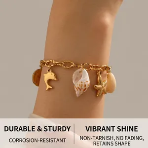 Gold stainless steel ocean charm bracelet featuring dolphin, conch, and starfish pendants