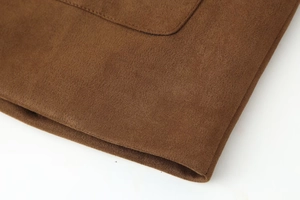 Macro detail of high-quality brown suede fabric with neat stitching and smooth texture