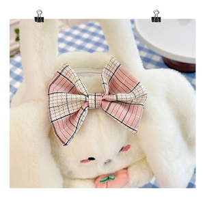 Detail of white plush rabbit handbag with pink checkered bow and zipper closure