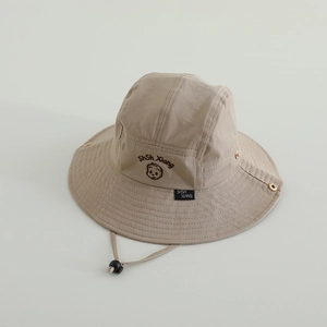 Detail of khaki cotton sun hat featuring adjustable wind cord and embroidered logo