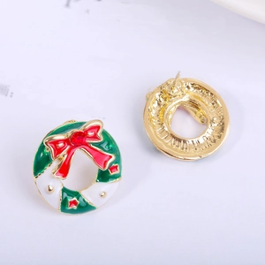 Macro view of Christmas wreath earrings with red bows and colorful enamel detail
