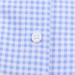 Close-up of blue and white plaid fabric showing stitching and white button detail