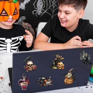 Kids in Halloween costumes looking at festive skull and ghost magnetic stickers on a laptop