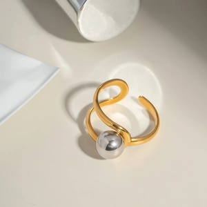 Dettaglio di un anello aperto bicolore con perle in finitura oro e argento