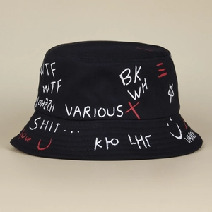 Close-up of a black bucket hat with white and red graffiti-style hand-drawn prints.