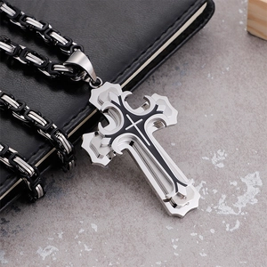 Macro detail of triple-layer black oil cross pendant with thick steel braid chain