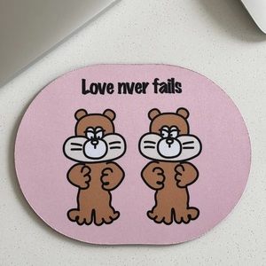 Detailed top view of a pink oval mouse pad featuring cute brown cartoon characters