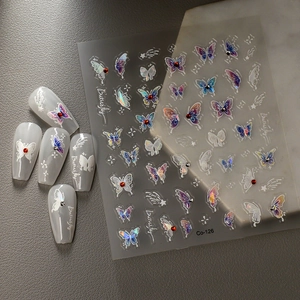 Dettaglio macro di adesivi per unghie a farfalla 3D con riflessi olografici e strass decorati
