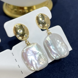 Macro detail of Edison baroque pearl earrings with gold-plated metal and tiny crystals