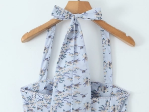 Detail view of the light blue dress with bee floral print and tie-up bow shoulder straps
