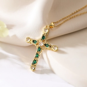 Luxurious gold cross necklace with emerald-cut green zircons and sparkling crystals