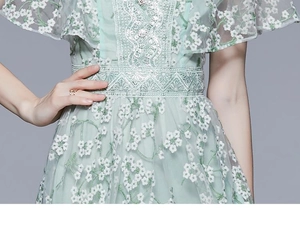 Detailaufnahme des minzgrünen Spitzenkleides mit floraler Stickerei und Taillenverzierung