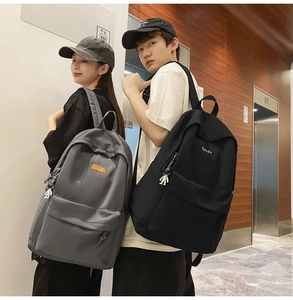 Detail of minimalist backpacks with COOLBOY logo and silver astronaut charms on straps