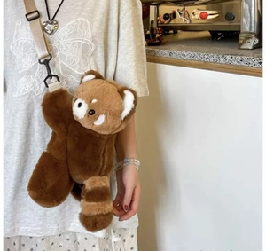 Adjustable beige strap on a cute brown red panda plush crossbody bag worn by a model