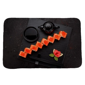 Tapis de sushi japonais avec rouleaux de saumon et œufs sur plateau en pierre noire