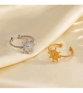 Detail of gold and silver sunburst rings with twisted bands on beige silk fabric