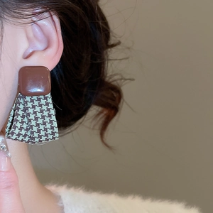 Detail of vintage geometric stud earrings with houndstooth fabric and brown square top
