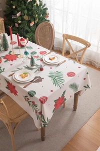 Close-up of Christmas tablecloth featuring red poinsettias and festive pine patterns