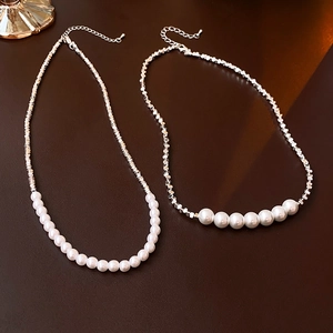 Vue détaillée de perles argentées irrégulières et de perles blanches sur le collier