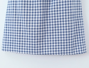 Nahaufnahme der blau-weiß karierten Stoffstruktur und Nahtdetails am Kleid
