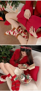 Macro detail of plush coral fleece Christmas socks featuring festive tree and berry patterns