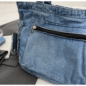 Close-up of blue denim tote bag texture with metal zipper and mini coin purse detail