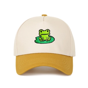 Detail of embroidered green frog on lily pad on a beige and tan trucker baseball cap