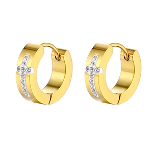 Detail of gold cross huggie earrings featuring sparkling cubic zirconia stones