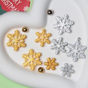 Close-up of glitter gold and silver snowflake charms in a heart-shaped tray