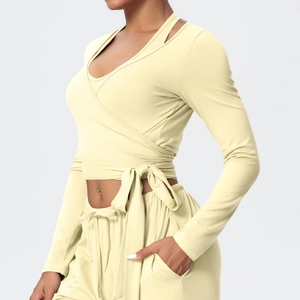 Detail view of cream-colored wrap long sleeve yoga top with adjustable waist tie