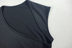 Detail of the elegant black dress showing the precise crossover neckline and shoulder stitching