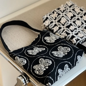 Close-up of retro butterfly embroidery on high-quality black canvas underarm bag