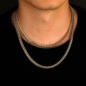 6mm gold-plated titanium steel Cuban link chain necklaces layered on a model with black background