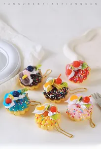 Macro shot of realistic artificial cream donuts with colorful fruit toppings and gold chain