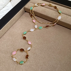 Close-up of multicolor marquise gemstones on a gold chain necklace in a jewelry tray