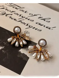 Gros plan détaillé des boucles d'oreilles vintage en forme d'éventail avec perles