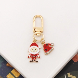 Close-up of Santa and Christmas hat metal keychain with glittery rhinestones