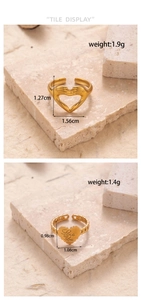 Detail of gold heart rings with Love You engraving and hands design on stone background