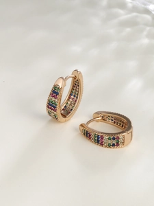 Macro shot of U-shaped rose gold earrings with rainbow pave-set crystals detail