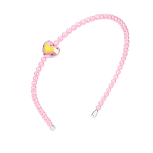 Detail of pink children headband with heart beads and faux pearls on white background