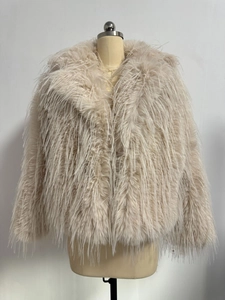 Detail of soft beige faux fur texture and high-density plush material on a short coat