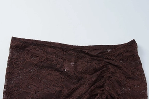 Detailed macro view of dark brown lace fabric with elegant floral hollow patterns